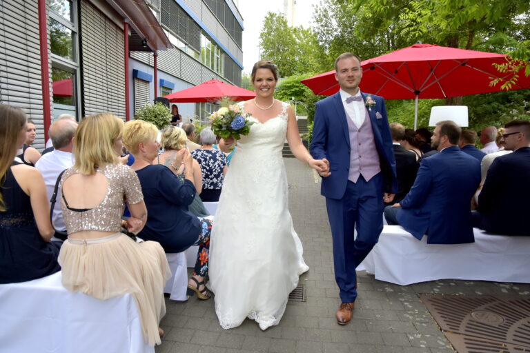 Auszug des Brautspaar nach der freien Trauung durch Traurednerin Vanessa Grasser. Sie sind gluecklich und lachen.
