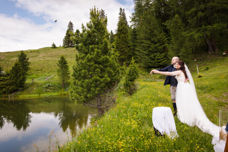 Ritual, bei dem Brautpaar Steine mit guten Wünschen in einen Bergsee in Tirol wirft.