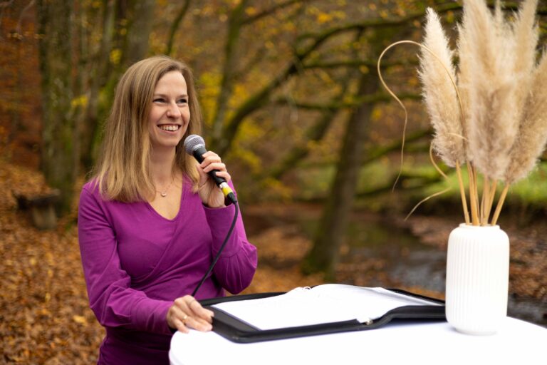 Traurednerin Vanessa Grasser spricht in einem herbstlichen Wald